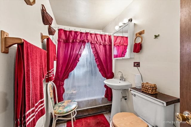 bathroom featuring curtained shower and toilet