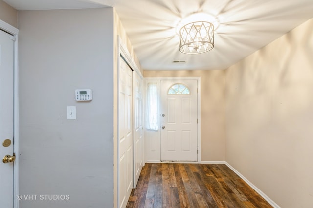 entryway with a chandelier and dark wood-type flooring