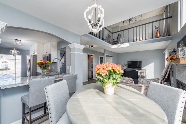 dining area with ornate columns and a notable chandelier