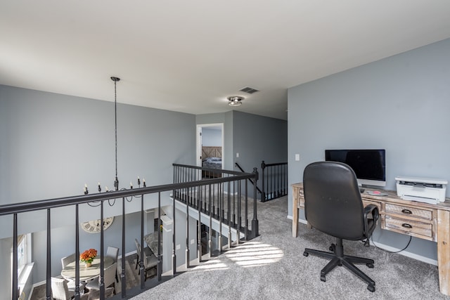 carpeted home office with a chandelier