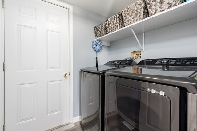 laundry area with wood-type flooring and washer and clothes dryer