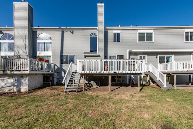 rear view of house with a deck, a lawn, and cooling unit