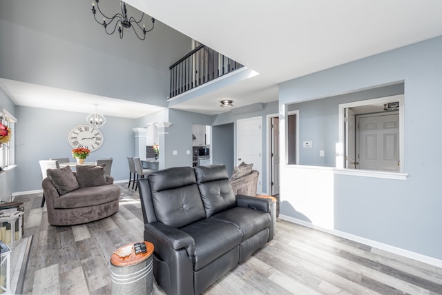 living room with light hardwood / wood-style flooring and an inviting chandelier