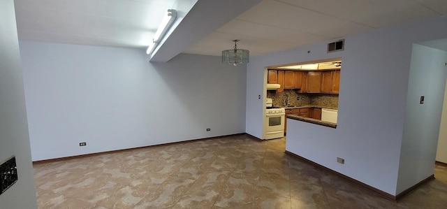 kitchen featuring pendant lighting, sink, decorative backsplash, white gas range, and a chandelier