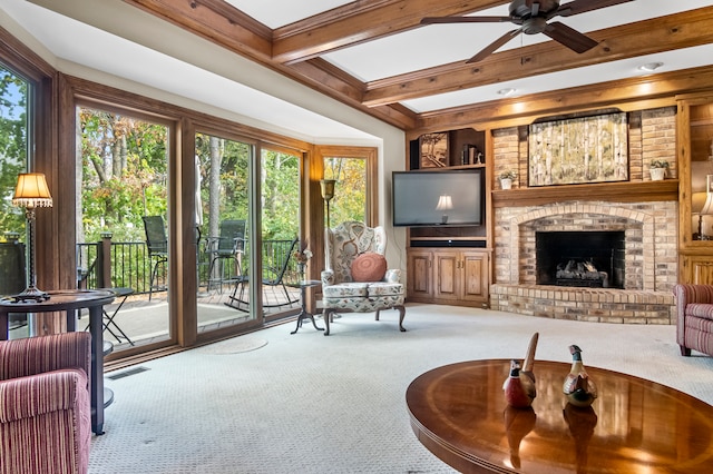 carpeted living room featuring beam ceiling, a brick fireplace, and ceiling fan