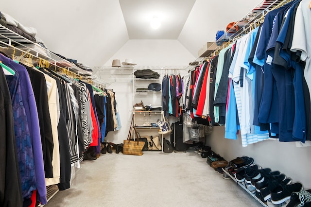 walk in closet featuring carpet flooring and vaulted ceiling