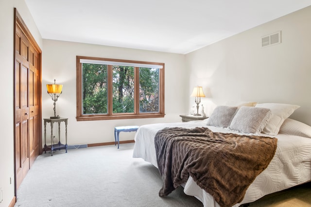 bedroom featuring light carpet and a closet