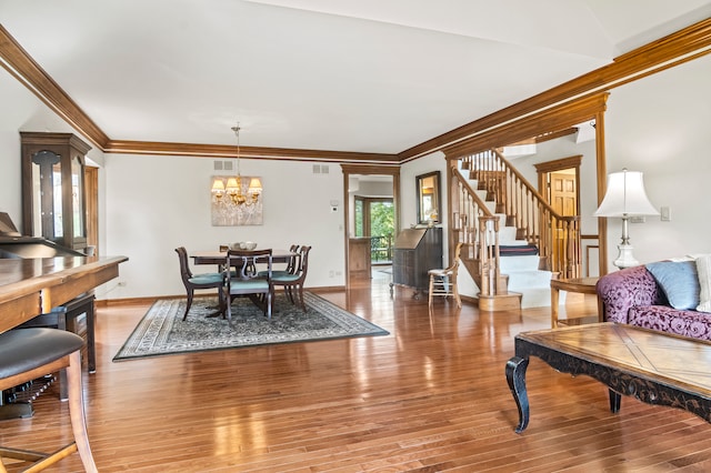 dining space with a notable chandelier, ornamental molding, and hardwood / wood-style flooring