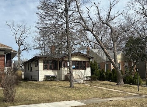 view of front of home with a front yard and a chimney