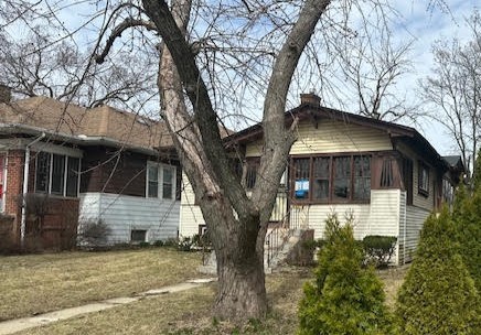 view of side of home featuring a chimney and a sunroom