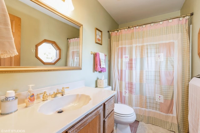 bathroom with toilet, vanity, and tile patterned floors