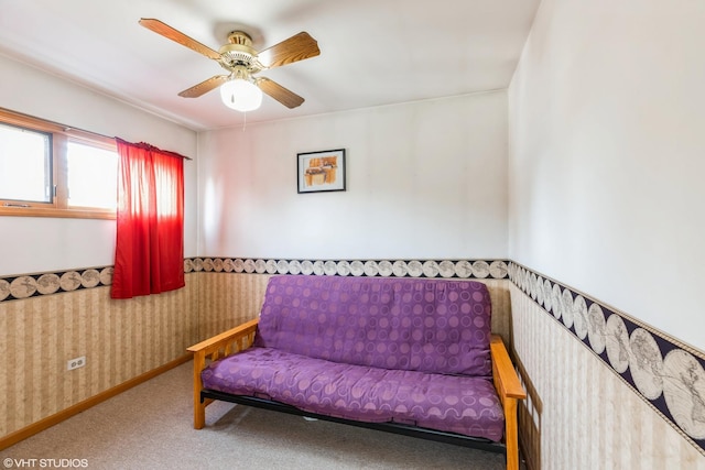 sitting room featuring baseboards, ceiling fan, carpet flooring, and wallpapered walls