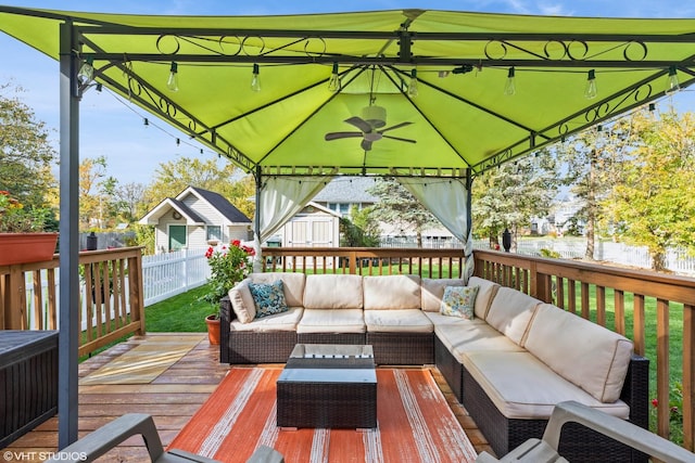 deck with a fenced backyard, an outdoor hangout area, and a gazebo