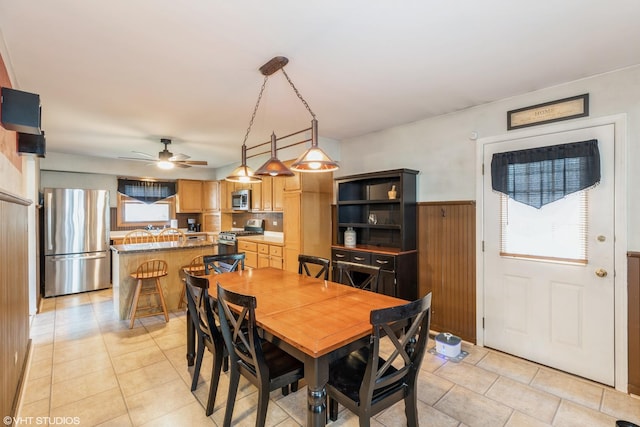 dining space with ceiling fan and light tile patterned floors