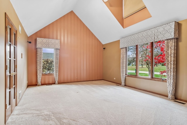 empty room featuring carpet and high vaulted ceiling