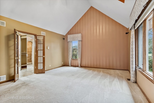 interior space featuring plenty of natural light, high vaulted ceiling, and french doors