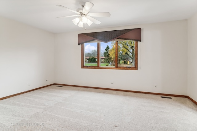 carpeted spare room with ceiling fan