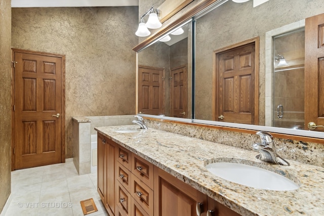 bathroom featuring tile patterned flooring, vanity, and walk in shower