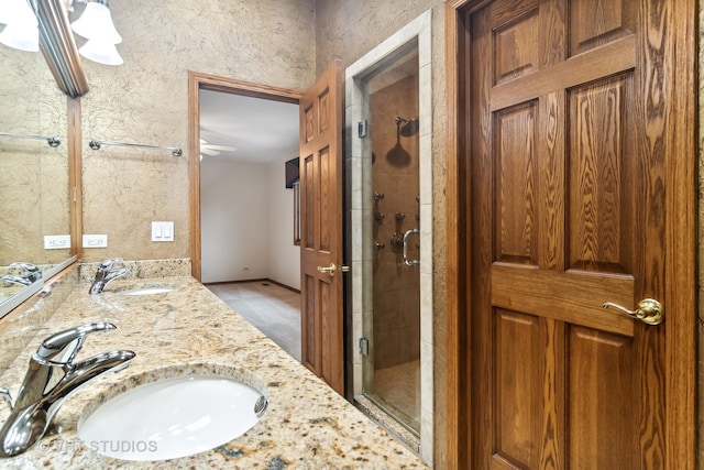 bathroom featuring tile patterned flooring, vanity, and a shower with door