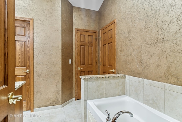 bathroom with tile patterned floors and a bathtub