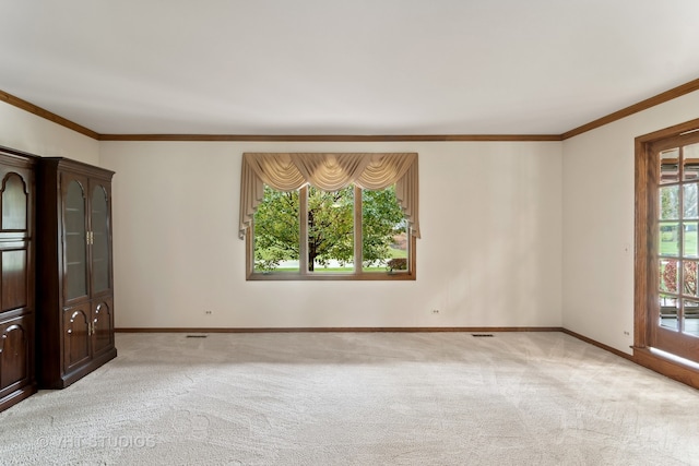 carpeted empty room featuring crown molding and plenty of natural light