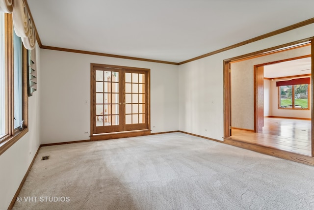 empty room featuring crown molding, light carpet, and french doors