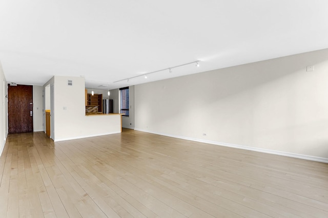 unfurnished living room featuring light hardwood / wood-style floors and rail lighting