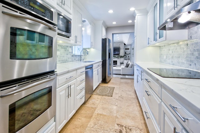 kitchen featuring stainless steel appliances, tasteful backsplash, and white cabinets