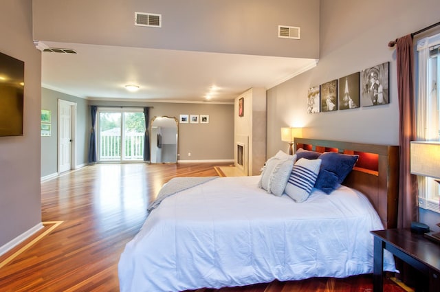 bedroom featuring wood-type flooring, access to outside, and crown molding