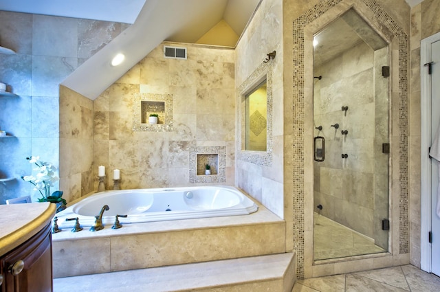 bathroom with tile walls, vanity, vaulted ceiling, and shower with separate bathtub