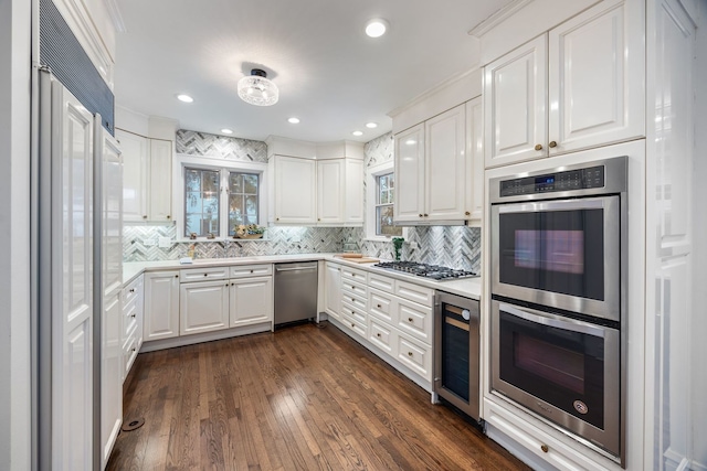 kitchen featuring stainless steel appliances, wine cooler, decorative backsplash, and white cabinetry