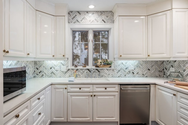 kitchen with sink, white cabinets, tasteful backsplash, and appliances with stainless steel finishes