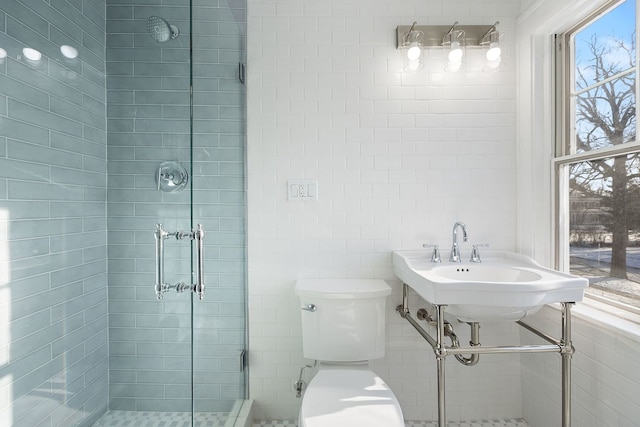 bathroom with toilet, an enclosed shower, and a wealth of natural light