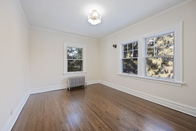 empty room featuring radiator heating unit, crown molding, and dark wood-type flooring