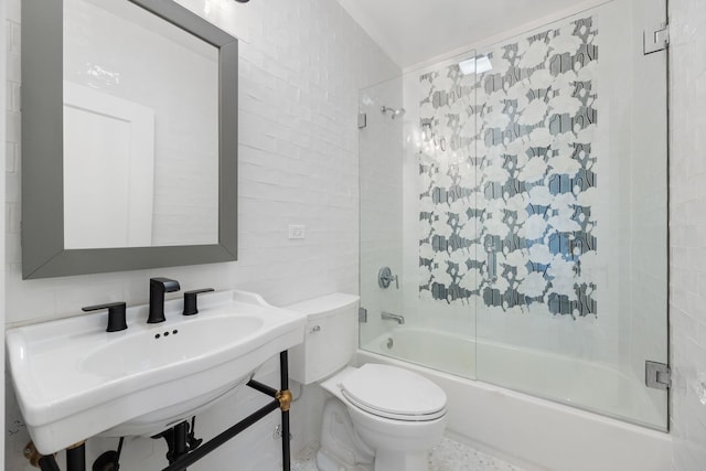 full bathroom featuring toilet, decorative backsplash, tile walls, bath / shower combo with glass door, and sink