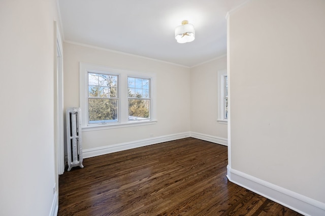 spare room with ornamental molding, radiator heating unit, and dark hardwood / wood-style floors