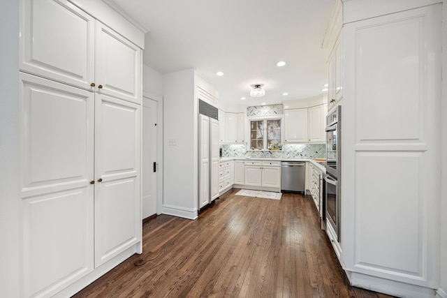 kitchen with sink, white cabinetry, stainless steel dishwasher, backsplash, and dark wood-type flooring