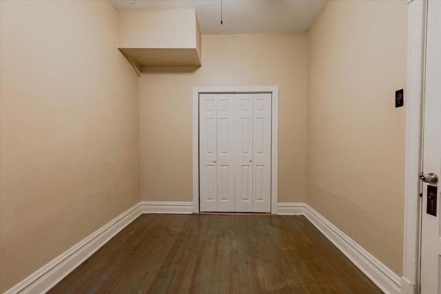 unfurnished bedroom featuring a closet and dark wood-type flooring