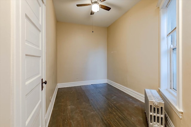 unfurnished room featuring dark hardwood / wood-style floors, radiator, and ceiling fan