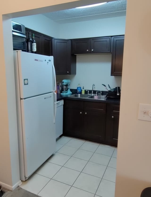 kitchen with white appliances, light tile patterned flooring, and sink