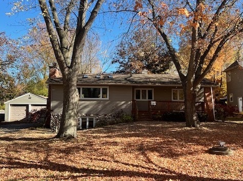 exterior space with a deck, a garage, and an outdoor structure