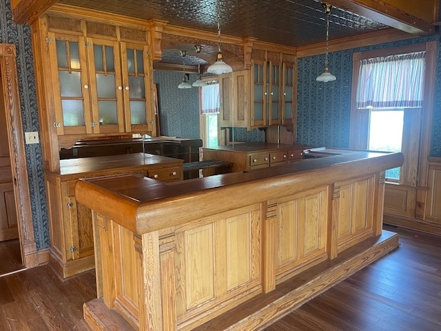 bar featuring butcher block counters, hanging light fixtures, dark hardwood / wood-style floors, and a healthy amount of sunlight