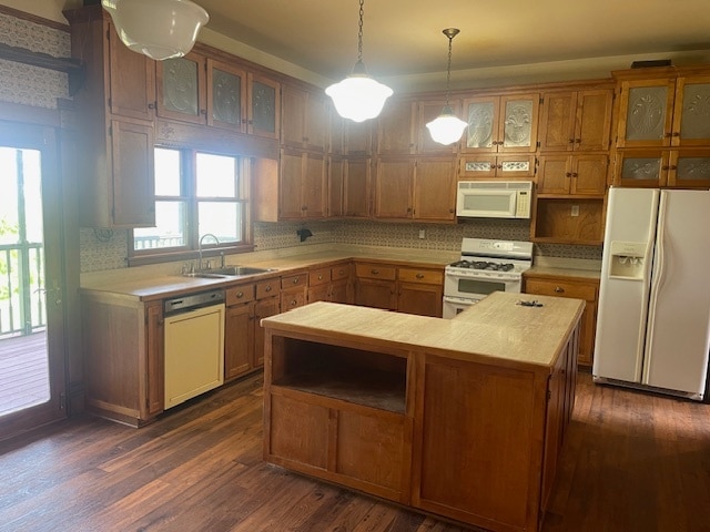 kitchen featuring backsplash, sink, dark hardwood / wood-style floors, and white appliances