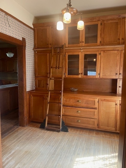 interior space with light hardwood / wood-style floors and hanging light fixtures