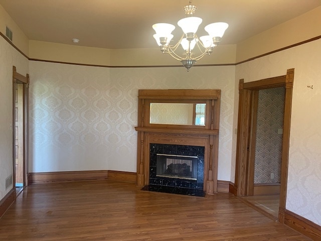 unfurnished living room with a chandelier and wood-type flooring