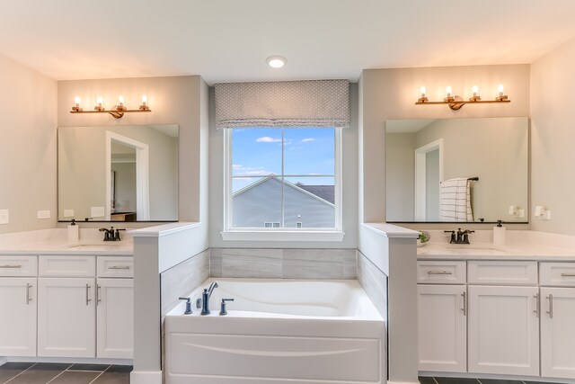 bathroom with vanity, a tub to relax in, and tile patterned flooring