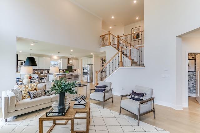 living room with light hardwood / wood-style floors and a high ceiling