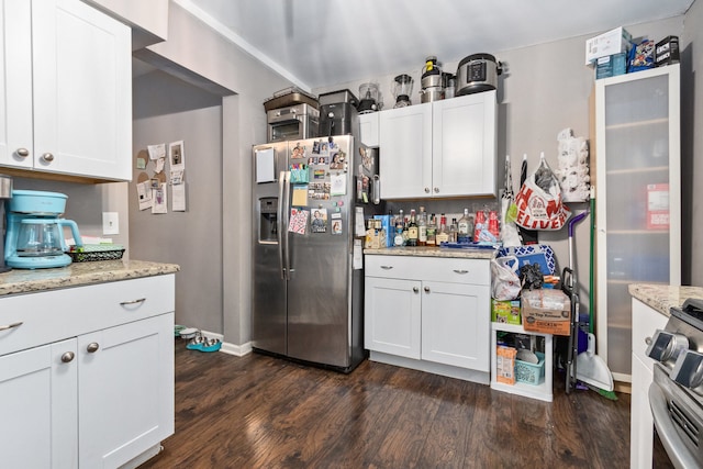 kitchen with dark wood-type flooring, white cabinetry, light stone countertops, and stainless steel appliances