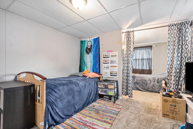 carpeted bedroom featuring a paneled ceiling