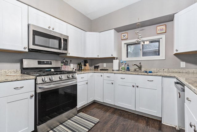 kitchen featuring white cabinets, appliances with stainless steel finishes, and dark wood-type flooring